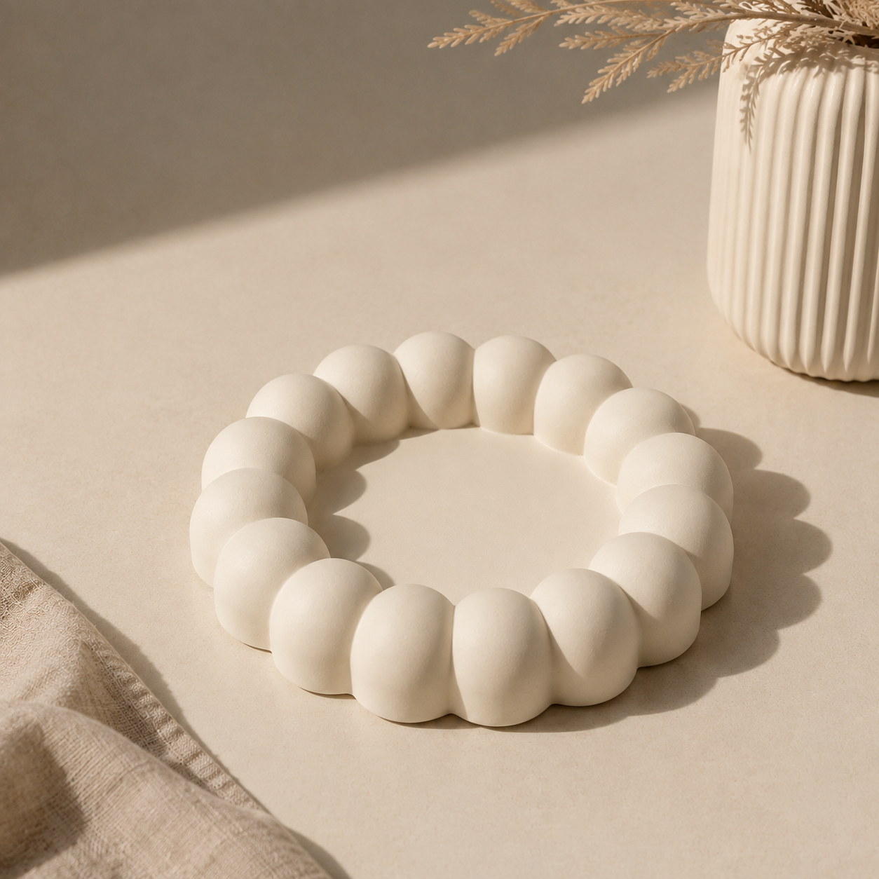 White bubble scallop ring holder tray on a beige surface