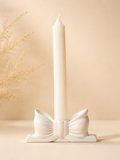 Matte white bow-shaped candle holder with taper candle